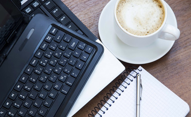 Office objects with laptop, coffee cup and a notebook