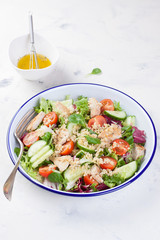 Salad with chicken, vegetables, bulgur and olive oil in an enamel plate. .