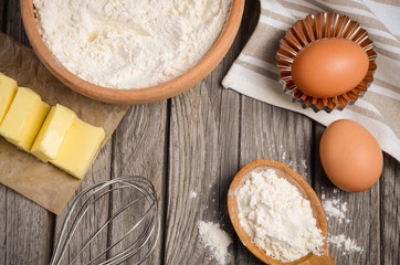 Ingredients for baking - milk, butter, eggs and flour. Rustic background. Horizontal permission. Top view.