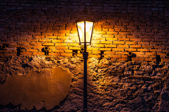 Vintage street lamp against a brick wall at night Stock Photo | Adobe Stock
