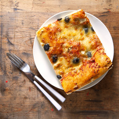 healthy slice of Italian pizza on a plate on a wooden background
