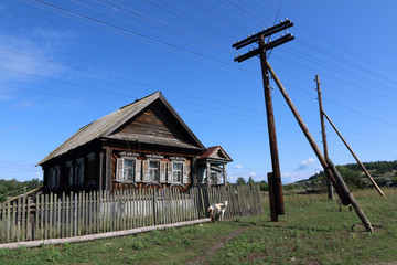 Very old wooden house in the remote Russian village in the summer against a blue sky