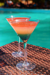 Cocktails on swimming pool background