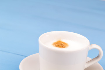 White cup of cappuccino on a table