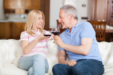 Mature couple enjoying a glass of red wine