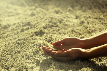 Hands holding a feather on grey carpet background, close-up