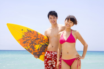 Young couple with a surfboard
