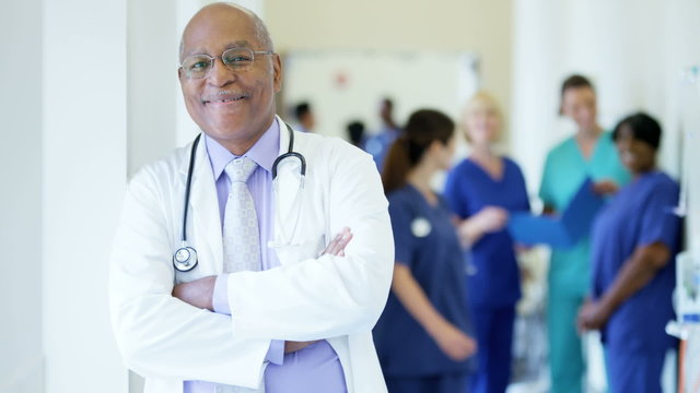Portrait of confident African American male hospital doctor wearing white coat