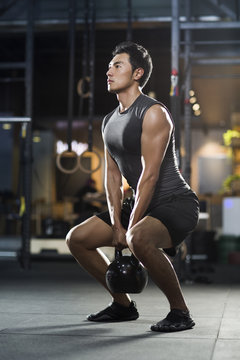 Man exercising with kettlebell in gym