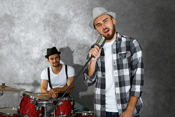 Musicians playing musical instruments and singing songs in a studio