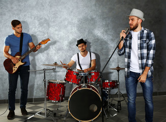 Musicians playing musical instruments and singing songs in a studio