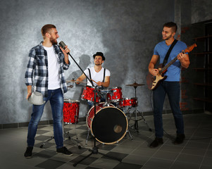 Musicians playing musical instruments and singing songs in a studio