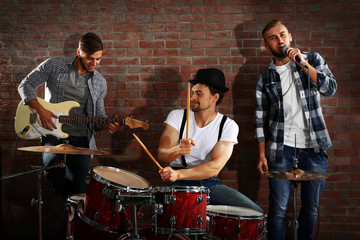 Musicians playing the drums on brick wall background