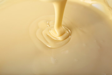 Background of condensed milk in a bowl, close-up