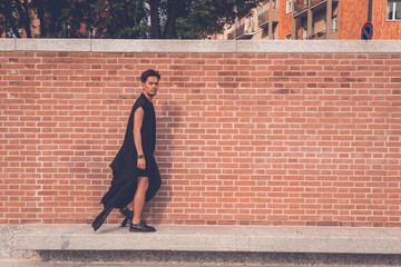 Handsome Asian model posing with a brick wall in background