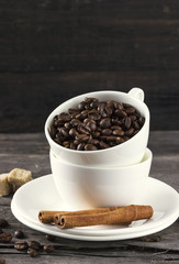 Coffee grains, sugar, cinnamon on dark wooden background