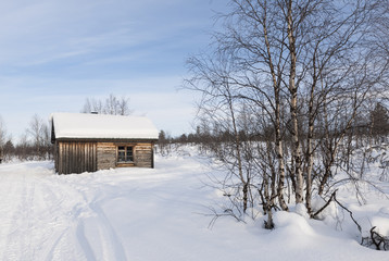 Fototapeta na wymiar Small House On Snow Covered Field