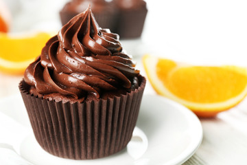 Cupcakes served with orange and drink on table