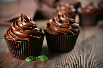 Chocolate cupcakes with mint on wooden table