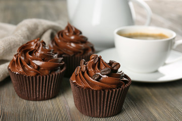 Chocolate cupcakes served with coffee on wooden table