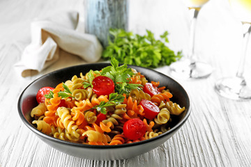 Delicious macaroni dish in black bowl on served grey wooden table