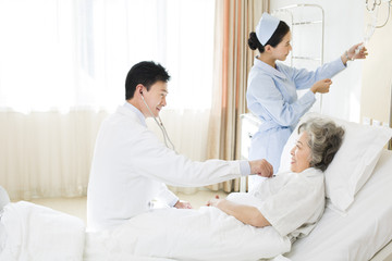 Fototapeta premium Doctor using stethoscope on patient in hospital