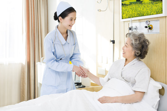 Nurse taking care of senior woman in hospital