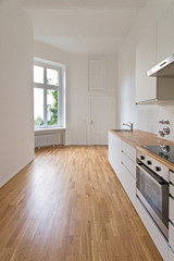 Fototapeta na wymiar empty kitchen, fresh renovated flat with wooden floor,