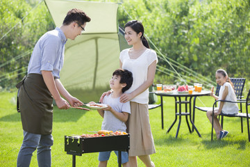 Young family barbecuing outdoors