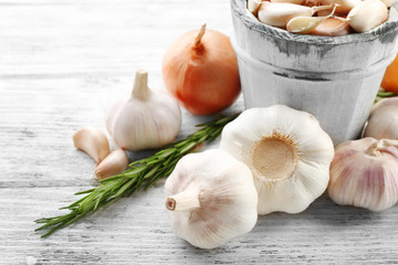 Composition of garlic, onion and rosemary on wooden table