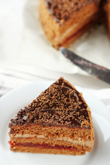 Sliced chocolate cake on plate, on wooden table  background