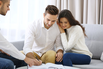 Estate agent meeting with happy couple, on light background