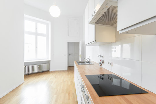 modern white kitchen with wooden floor, renovated flat