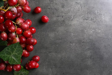 Bunch of grape with green leaves on grey background, copy space