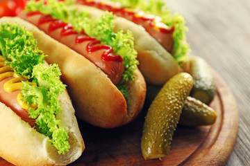 Tasty hot-dogs with vegetables on wooden table, close up
