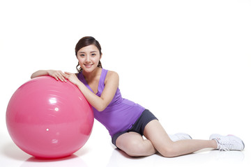 Fototapeta na wymiar Young woman leaning on a fitness ball