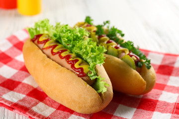 Delicious hot-dogs on red checkered cotton napkin, close up