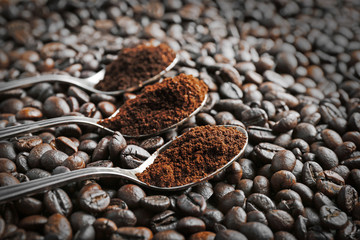 Spoons with coffee on coffee beans, close up