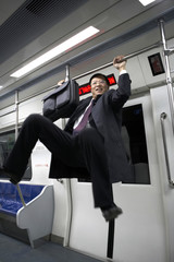 Man Swinging On Handrail In Train
