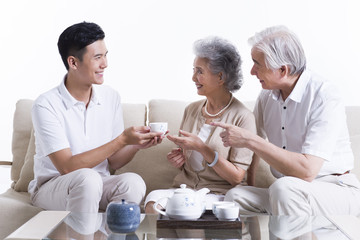 Obraz premium Happy family having tea and chatting