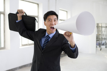 Fototapeta premium Excited businessman cheering through a megaphone