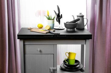 Sliced lemon and tableware on kitchen table, close up