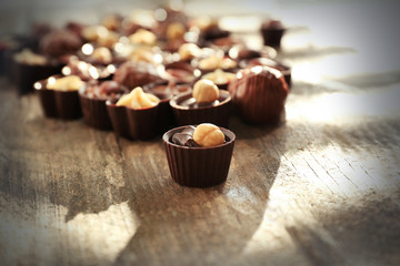 Delicious chocolate candies on wooden background, close up
