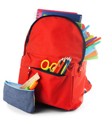 Red backpack with colourful stationary and pencil case isolated on white background