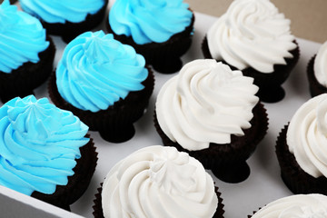 Tasty cupcakes in paper box, close up