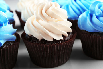 Fresh delicious cupcakes in a row, close up