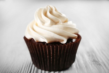Tasty cupcake on white wooden background