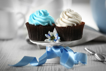 Chocolate cupcakes with colourful cream on decorated table , close up
