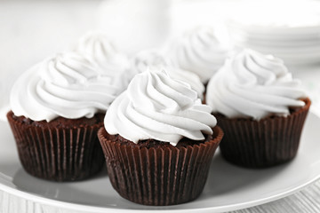 White cupcakes on wooden table