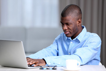 African American businessman in blue shirt with laptop, close up